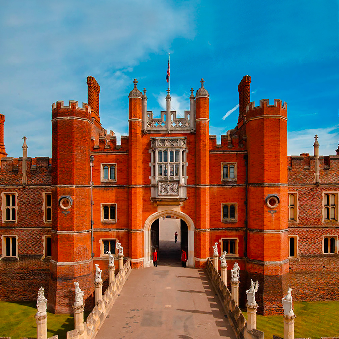 Hampton Court Palace entrance with red brick towers and statues, London, England.