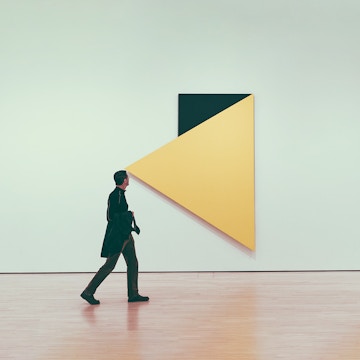 Person walking past abstract art at MOMA, New York City.