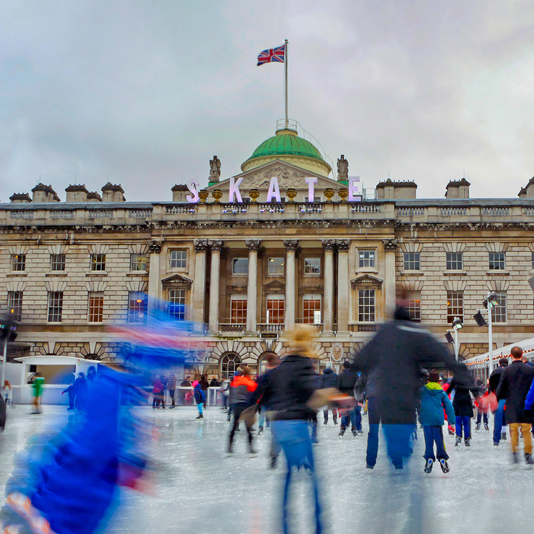 Ice skaters at Somerset House in London with historic building in background.