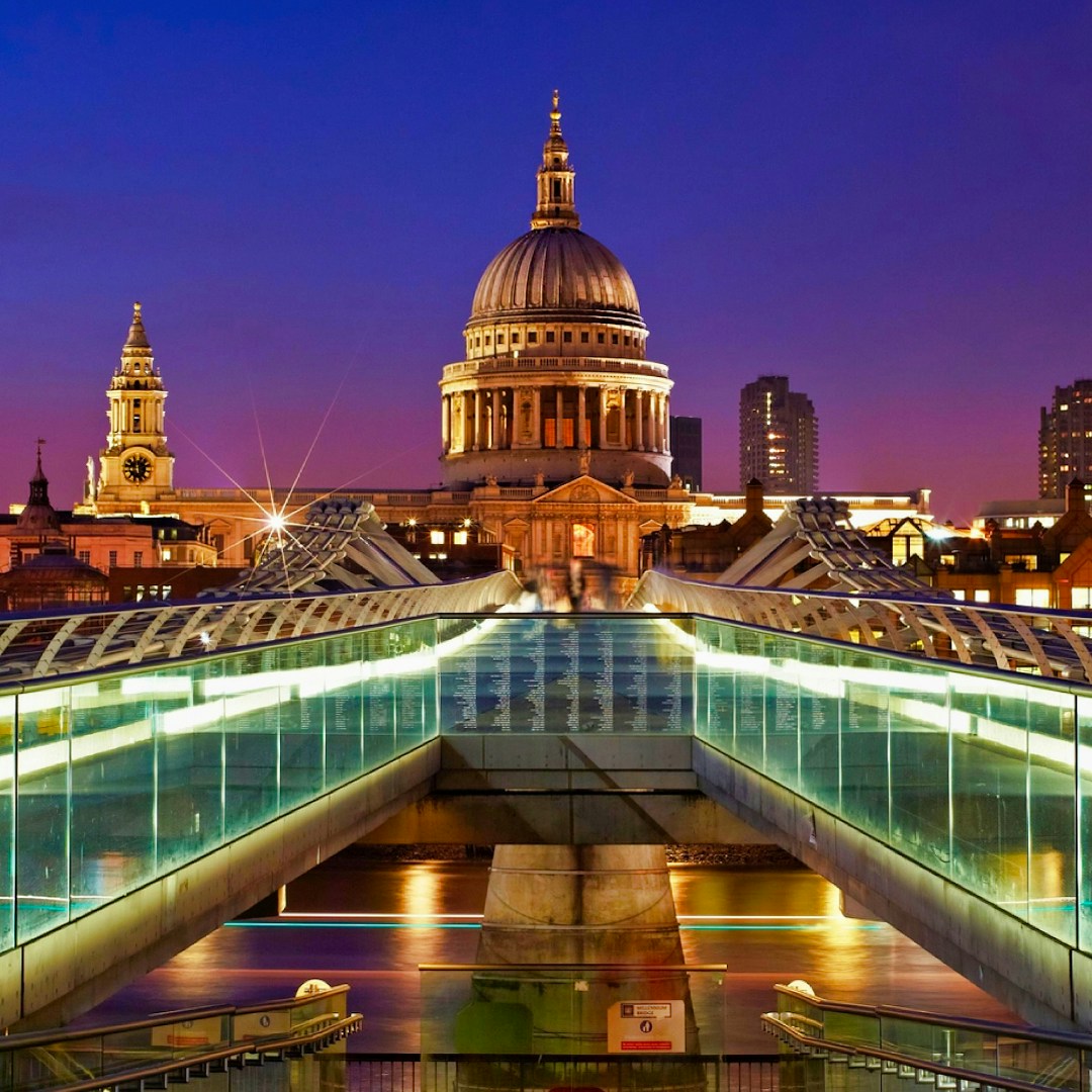 Millennium Bridge leading to St Paul's Cathedral in London at dusk.
