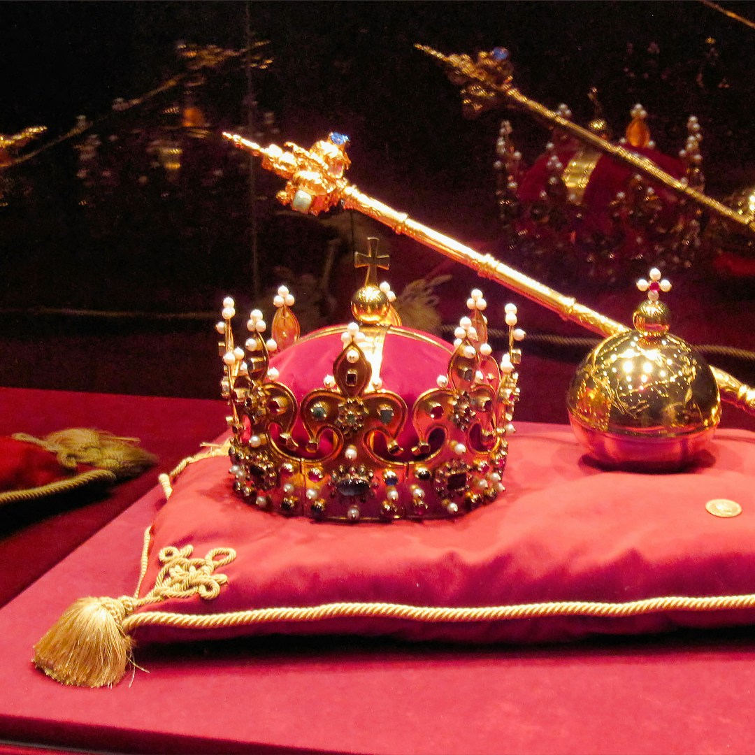 Crown Jewels display at the Tower of London, featuring a crown, scepter, and orb.