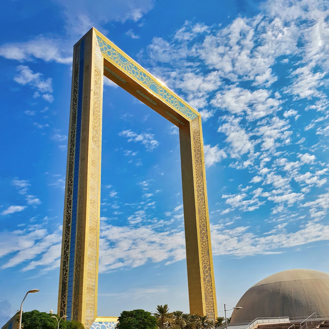 Dubai Frame against a blue sky, showcasing its architectural design.