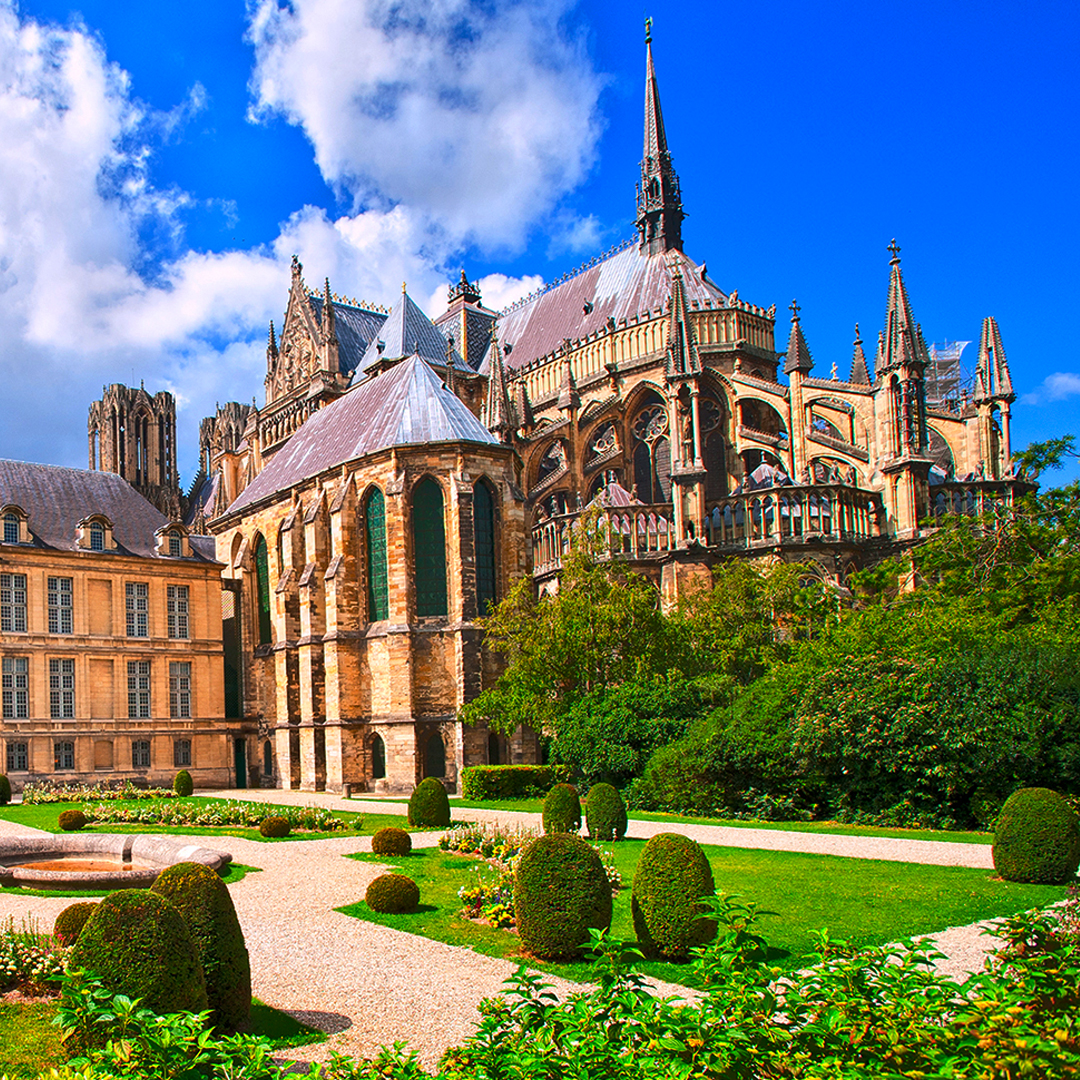 Reims Cathedral exterior with gardens, part of the Guided Tour of Reims Champagne & Mumm House from Paris.