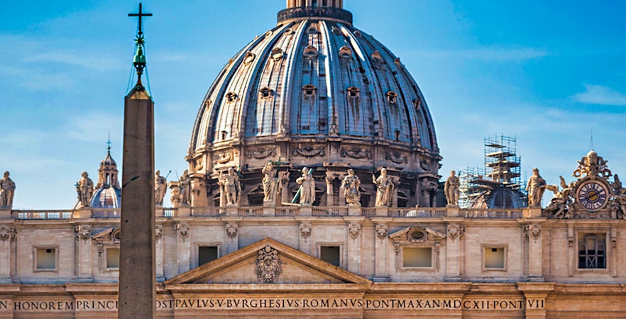 Vatican Museums and Sistine Chapel entrance with St. Peter's Basilica dome in Rome.